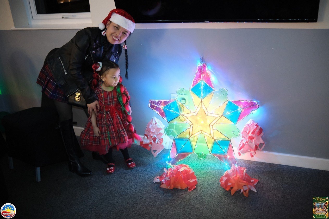 Child beside a glowing Filipino Christmas parol